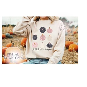 May include: A beige sweatshirt with a graphic of colorful pumpkins and the text "pumpkin season".