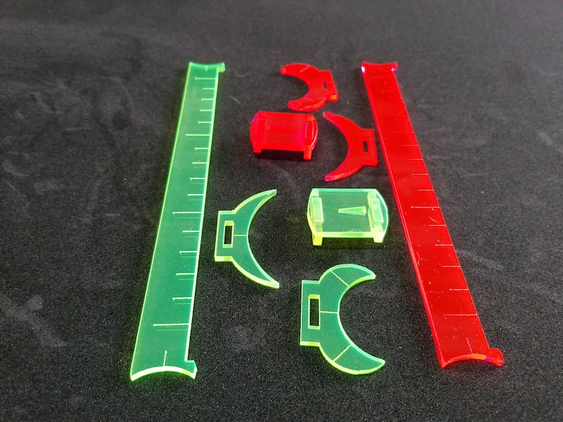 May include: A set of green and red plastic rulers and protractors. The rulers are marked with inches and the protractors are marked with degrees.