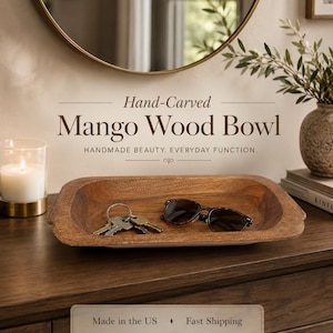 May include: A rectangular hand-carved mango wood bowl with a natural brown grain finish. The bowl contains a set of metal keys and dark-rimmed sunglasses. The text Hand-Carved Mango Wood Bowl and HANDMADE BEAUTY. EVERYDAY FUNCTION. is visible above.
