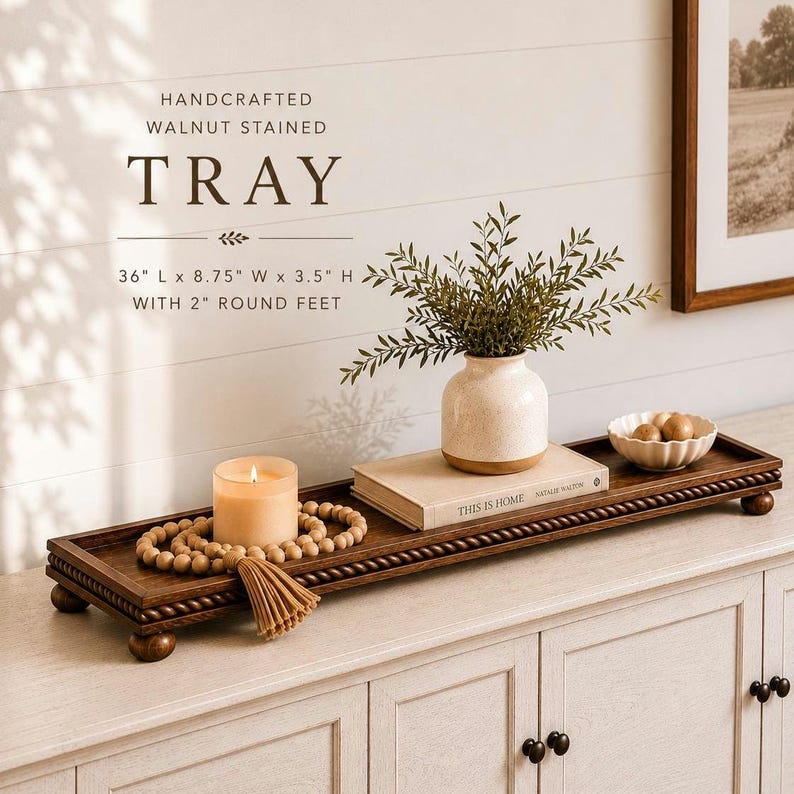 May include: A rectangular walnut stained wooden tray with a rope-style border and four round feet. The tray measures 36 inches long, 8.75 inches wide, and 3.5 inches high, including the 2-inch round feet. It features a dark brown wood finish.