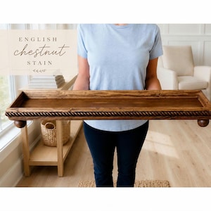 May include: A rectangular wooden tray with a dark brown English chestnut stain. The tray features a decorative rope-style border along the edges and is supported by four small, rounded ball feet. The text "ENGLISH chestnut STAIN" is visible.