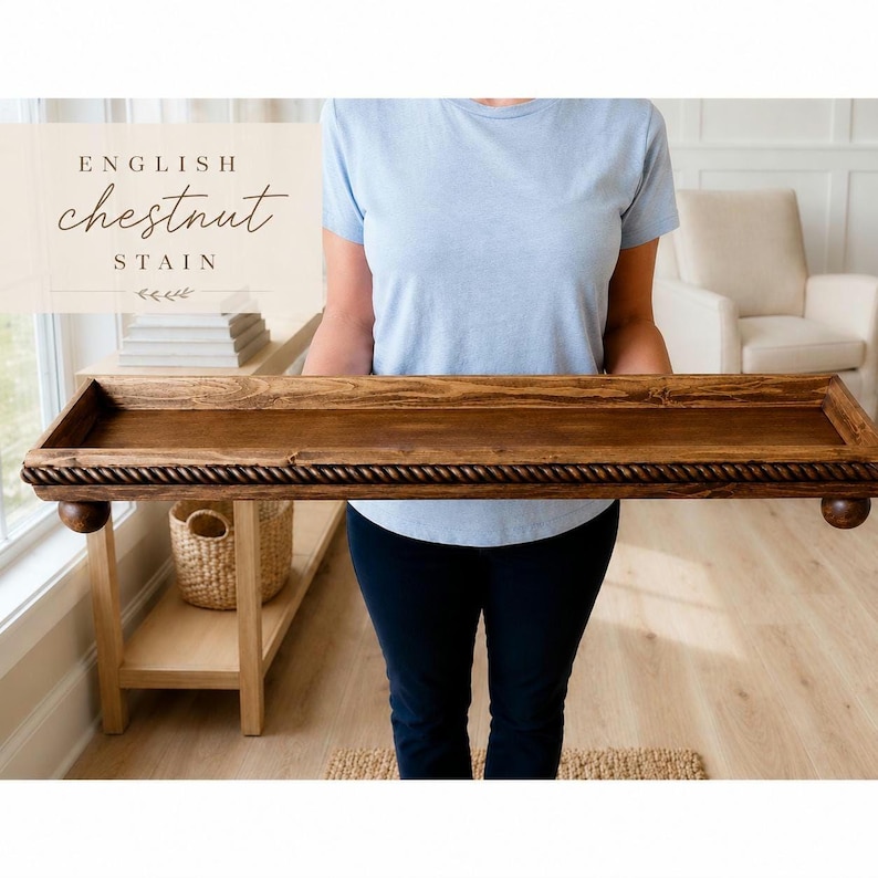 May include: A rectangular wooden tray with a dark brown English chestnut stain. The tray features a decorative rope-style border along the edges and is supported by four small, rounded ball feet. The text "ENGLISH chestnut STAIN" is visible.