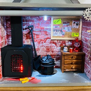 May include: A miniature diorama of a brick building with a black fireplace, a small wooden dresser, and a red lantern. The diorama is decorated with a brick wall, a metal pipe, and a sign that reads "Girl Lost".