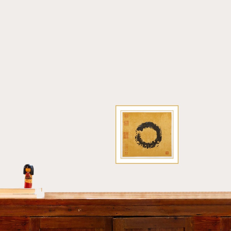 Enso painting on the wall above large wooden workbench. A book and a Japanese kokeshi doll are on the workbench for demonstration purposes.