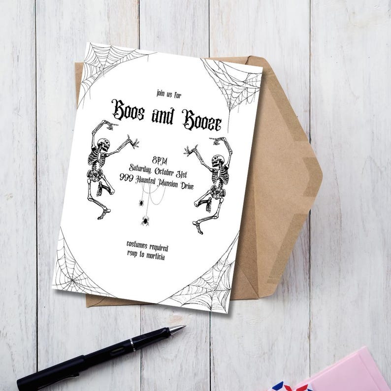 May include: A Halloween invitation with the text "Boos and Booze" and skeleton illustrations. The invitation is white with black text and graphics, and is placed on a wooden surface with a brown envelope and a black pen.