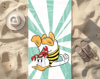 May include: A beach towel with a cartoon duck wearing a yellow and black striped shirt and holding a red crab. The background is a teal and white striped pattern.