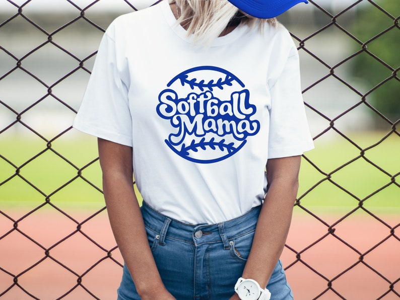 May include: White t-shirt with a blue softball graphic and the text "Softball Mama" in a retro font.