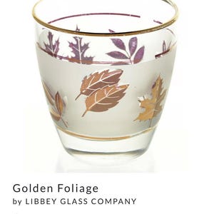 May include: A clear glass tumbler with a gold rim and a frosted design of leaves in shades of brown, purple, and gold. The words "Golden Foliage" are printed on the glass.