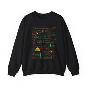 Puede incluir: Sudadera negra con una impresión blanca de citas famosas de la película "Vacaciones de Navidad". Las citas están en texto rojo, verde y amarillo.