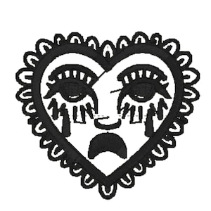 May include: Black embroidered heart-shaped patch featuring a face design. The face has large eyes with long lashes, a small nose, and a downturned mouth. The word "MIM" is written below the eyes. The heart is outlined with a scalloped border.