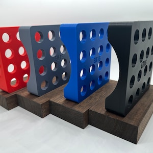 May include: Four 3D printed storage organizers in red, gray, blue, and black, each with a grid of circular holes and the text "ER16" printed on the side. The organizers are displayed on wooden bases.