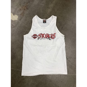 May include: White tank top with a red Harley Davidson logo and the text "Sturgis 2005" printed on the front.