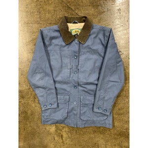 Puede incluir: Una chaqueta vaquera azul con cuello de pana y varios bolsillos. La chaqueta tiene cierre de botones y está hecha por la marca "Coldwater Creek".