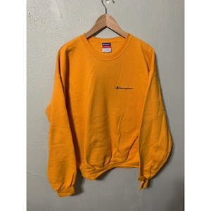 May include: A yellow Champion sweatshirt with a small black embroidered logo on the front.