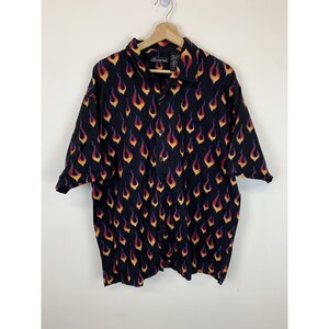 May include: A black short-sleeved button-down shirt with an all-over print of orange, yellow, and red flames.