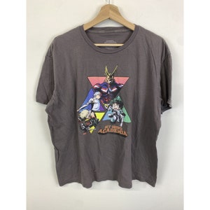 May include: A dark gray t-shirt with a graphic print of characters from the anime My Hero Academia. The characters are in a triangle shape with the text "My Hero Academia" below them.