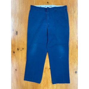 Könnte beinhalten: Eine dunkelblaue Arbeitshose mit geradem Bein und flachem Vorderteil. Die Hose hat einen Reißverschluss und Gürtelschlaufen. Der Markenname "874" ist auf dem Bund sichtbar.