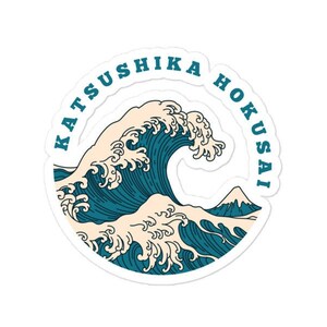 Könnte beinhalten: Ein runder Aufkleber mit einer teal- und weißen Illustration einer großen Ozeanwelle und einem Berg. Die Worte "Katsushika Hokusai" sind in Teal um den Rand des Aufklebers gedruckt.