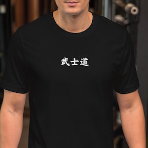 May include: Black t-shirt with the Japanese characters for "Bushido" printed in white. The shirt is a crew neck style and is being worn in a gym setting.