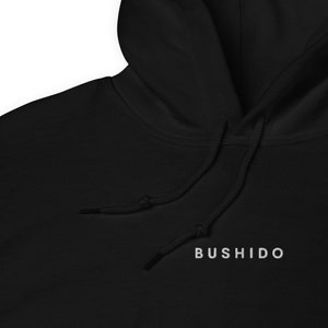 May include: Black hooded sweatshirt with a white drawstring and the word "BUSHIDO" printed in white on the front.