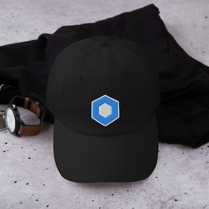 May include: A black baseball cap with a blue and white hexagonal logo embroidered on the front.