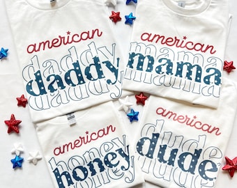 Pode incluir: Quatro camisetas brancas com texto vermelho e azul que diz "american" e uma palavra em maiúsculas com estrelas dentro das letras. As palavras são "daddy", "mama", "honey" e "dude".