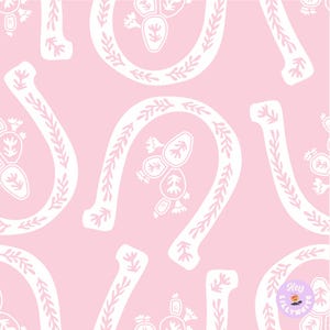 May include: A repeating pattern of white horseshoes, sprigs, and floral designs on a light pink background. The horseshoes are outlined with a leafy pattern and have a small floral design in the center. The overall design is whimsical and decorative.