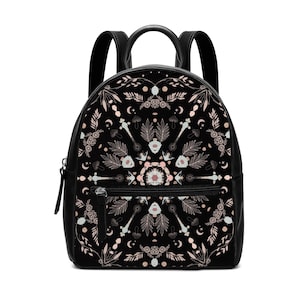 Può includere: Zaino nero con un motivo decorativo con elementi botanici e celesti nei toni del rosa, beige e bianco. Il design include foglie, funghi, lune e altre forme stilizzate. Lo zaino ha spallacci neri e una tasca frontale con cerniera.