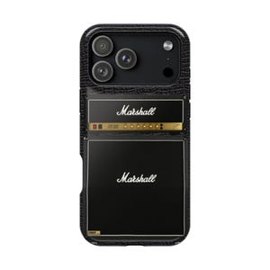 May include: Black phone case featuring a Marshall amplifier design. The case has a textured, leather-like appearance and includes the Marshall logo in white. The design mimics the look of a classic guitar amplifier, with a gold and black color scheme.