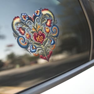 May include: A heart-shaped car window sticker with a floral design. The sticker features a vibrant mix of colours including red, blue, and yellow. The decorative sticker is a unique car accessory, adding a touch of personality to the vehicle.