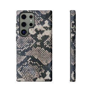 May include: A black and white snakeskin patterned phone case for a smartphone.
