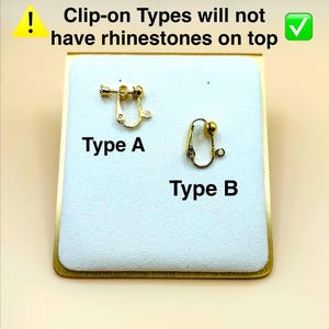 May include: Two gold-toned metal clip-on earring findings labelled Type A and Type B. Type A features a screw-back mechanism, while Type B is a standard clip-on. Text states: Clip-on Types will not have rhinestones on top.