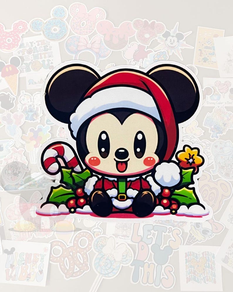May include: A sticker featuring a cartoon Mickey Mouse character in a Santa hat and outfit, holding a candy cane. The design includes holly and berries, with a cheerful expression. The sticker is surrounded by other Disney-themed stickers.