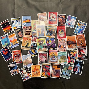 May include: A collection of colorful vintage-style stickers featuring various Disney World attractions, including Space Mountain, The Great Movie Ride, and Soarin'. The stickers are printed with the EPCOT logo and feature various ride names and locations.