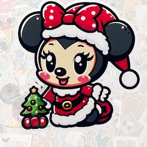 May include: A cartoon sticker of a character wearing a Santa Claus outfit. The character has black ears, a red and white polka dot bow, and a red Santa hat. The character is holding a small green Christmas tree.