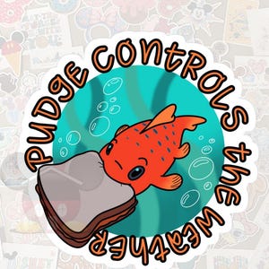 May include: A sticker featuring a cartoon goldfish with orange scales and blue eyes, biting a sandwich. The sticker has the text "Pudge controls the weather" in a circular design with orange and black lettering. The background is teal with bubbles.