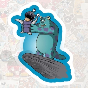 May include: A sticker featuring Sully from Monsters, Inc. holding Boo. Sully is a large, blue monster with purple spots, and Boo is wearing a monster costume. The sticker is outlined in white and set against a blue background, with other stickers in the background.