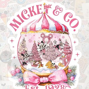 May include: A sticker featuring a pink and white circus tent design with the text "Mickey & Co." and "Est. 1928". Inside a snow globe are cartoon characters Mickey, Minnie, Donald, and Goofy, with pink Christmas trees.