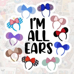 May include: A sticker sheet featuring various mouse ear headbands in different colors and patterns, including polka dots and bows. The phrase "I'M ALL EARS" is prominently displayed in bold, black letters.