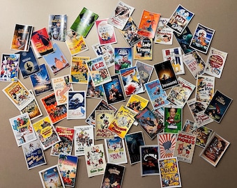 May include: A collection of vintage Disney movie posters, featuring colorful illustrations and titles like "Lady and the Tramp," "Pinocchio," and "Peter Pan." The posters showcase classic animation styles and are arranged on a neutral surface.