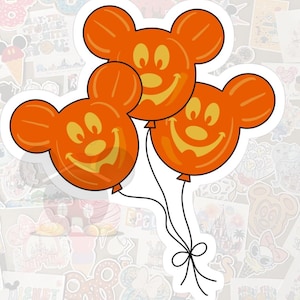 May include: Three orange Mickey Mouse-shaped balloons with smiling jack-o'-lantern faces. The balloons are connected by black strings tied with a bow. The stickers are on a white background with other Disney-themed stickers.