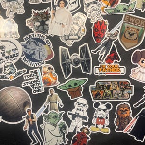May include: A collection of Star Wars themed stickers featuring characters like Darth Vader, Yoda, and Princess Leia. The stickers are colorful and include text like "May the 4th" and "I'm your father".