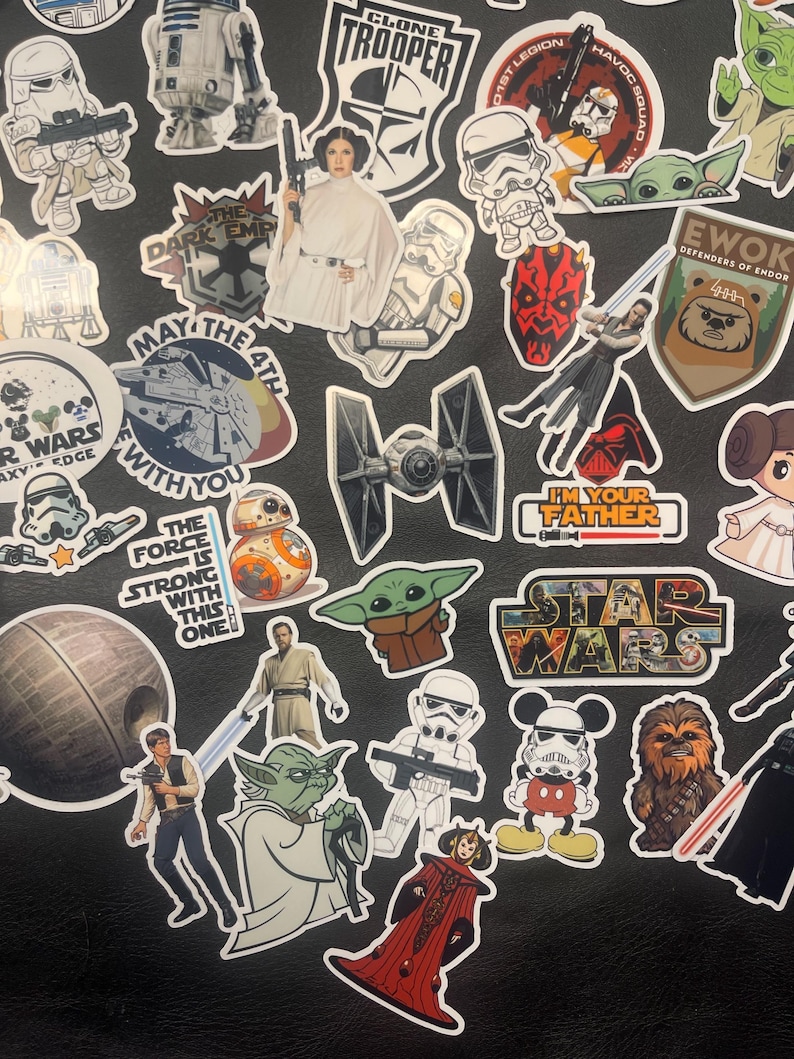 May include: A collection of Star Wars themed stickers featuring characters like Darth Vader, Yoda, and Princess Leia. The stickers are colorful and include text like "May the 4th" and "I'm your father".