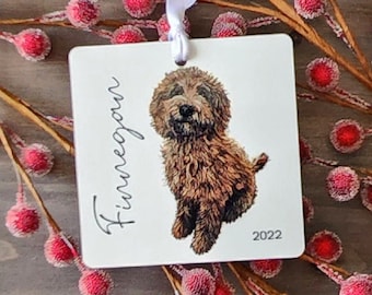 May include: White ceramic ornament with a brown dog illustration and the name "Finnegan" written in cursive. The year "2022" is printed in the bottom right corner.