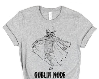 May include: A gray t-shirt with a black and white illustration of a goblin wearing a pointed hat and holding a cape. The text "GOBLIN MODE" is printed below the illustration.