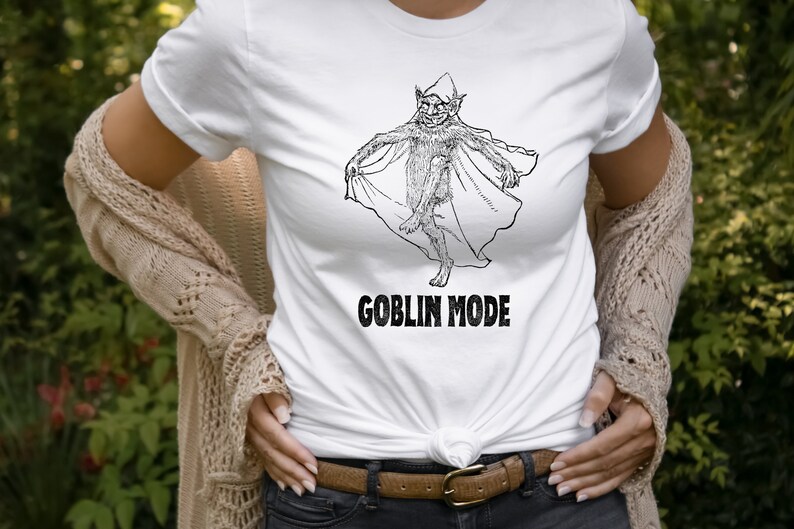 May include: White t-shirt featuring a black and white illustration of a goblin wearing a hat and holding a cape. The text "GOBLIN MODE" is printed below the illustration.