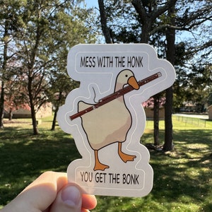 May include: A white goose sticker with a red oboe, the text "MESS WITH THE HONK" and "YOU GET THE BONK" on a white background.