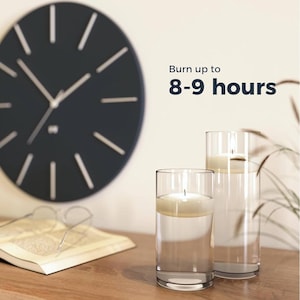 May include: Two clear glass cylinder vases with white candles inside. The candles are floating in water. The text "Burn up to 8-9 hours" is visible in the image.