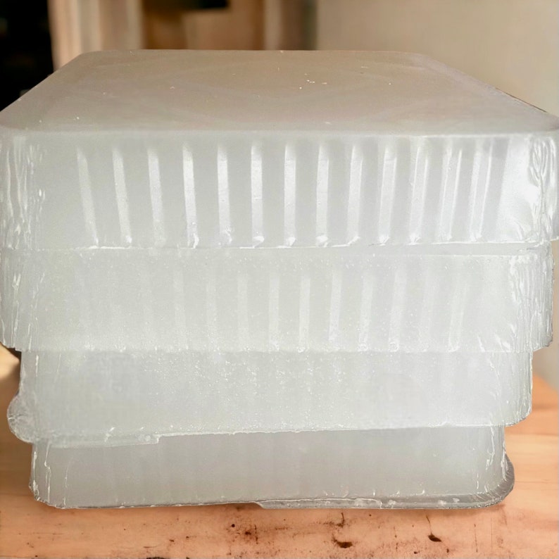 May include: Stack of four clear, rectangular blocks with a textured surface. The blocks are stacked on top of each other.