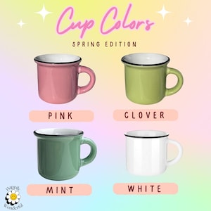 May include: Four ceramic mugs with black rims and white interiors, labeled Cup Colors Spring Edition. The mugs are pink, clover green, mint green, and white. Each mug has a rounded handle and a smooth finish. A small flower logo is in the corner.